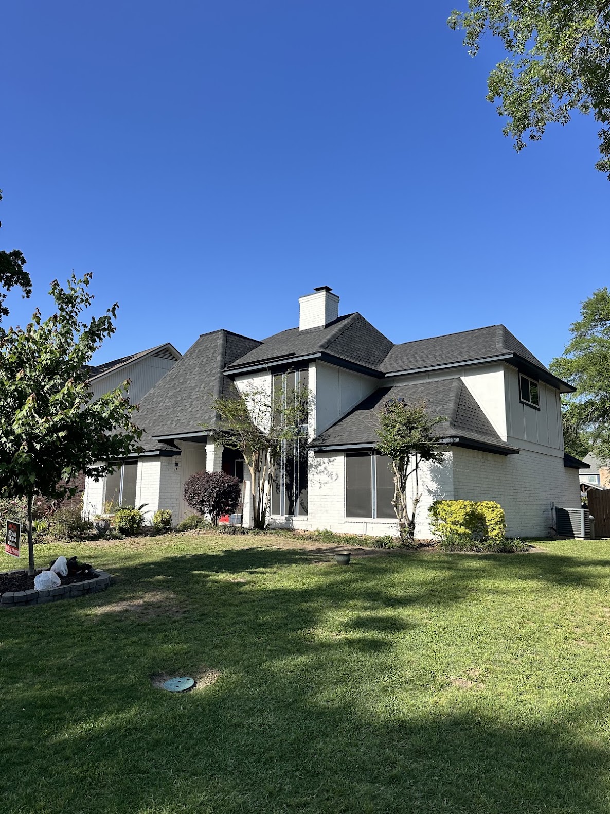Completed dark shingle roof on large two-story exterior home